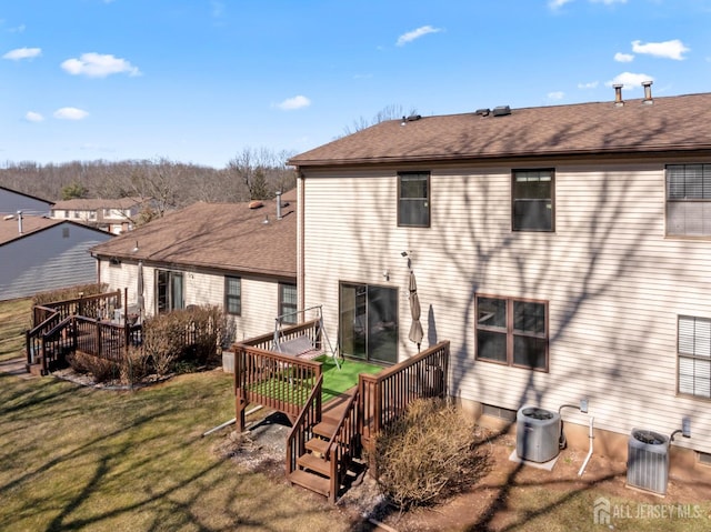 rear view of house with a lawn, cooling unit, and a deck