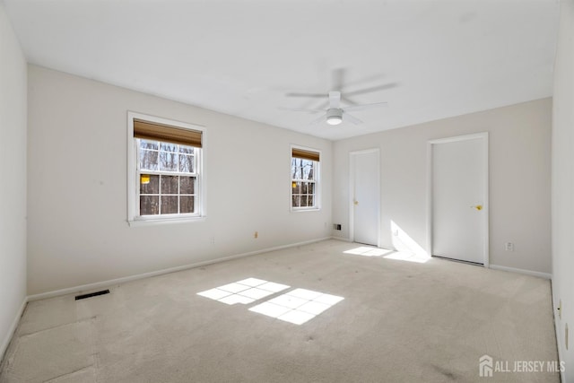 unfurnished room with carpet flooring, ceiling fan, baseboards, and visible vents