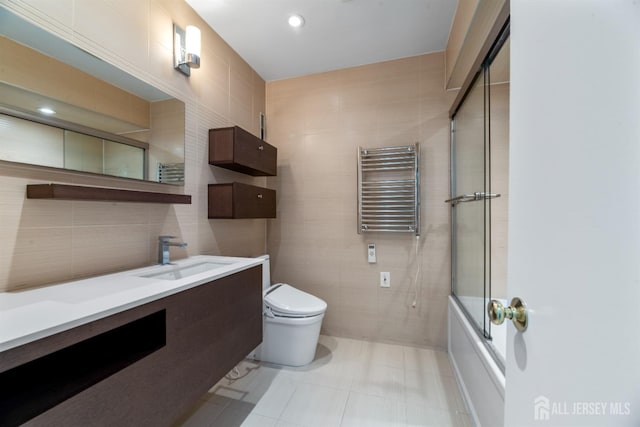 full bath featuring toilet, tile walls, radiator heating unit, and vanity