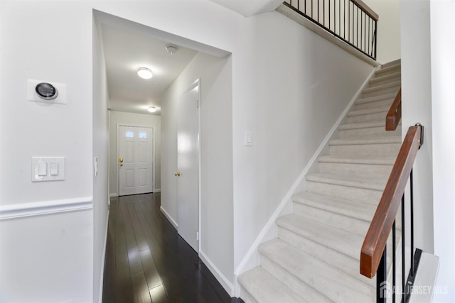 stairway with wood finished floors and baseboards