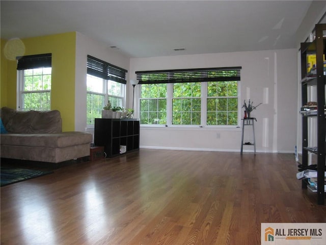 living room with dark wood-type flooring and a wealth of natural light