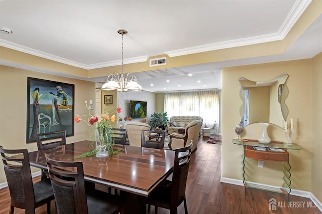 dining space with a notable chandelier, dark wood-type flooring, and ornamental molding