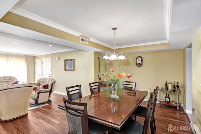 dining area with wood-type flooring, ornamental molding, and a chandelier