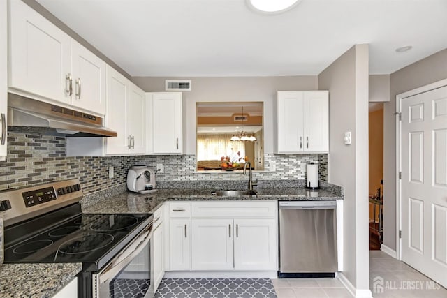 kitchen featuring appliances with stainless steel finishes, sink, dark stone counters, and white cabinets