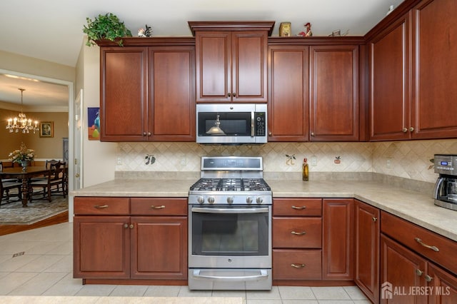 15 Heather Ct, Mansfield, NJ 08022 - kitchen with stainless steel appliances, light tile patterned flooring, a chandelier, backsplash, and ornamental molding