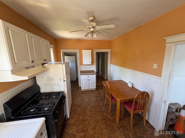134 S Stevens Ave S, South Amboy, NJ 08879 - kitchen featuring black gas range, wainscoting, white cabinetry, ceiling fan, and under cabinet range hood