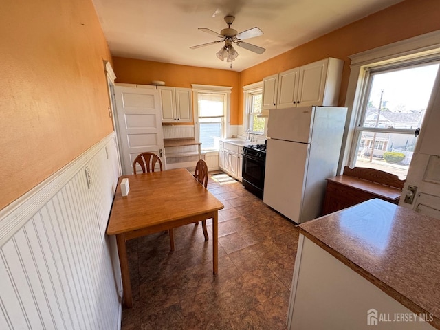 134 S Stevens Ave S, South Amboy, NJ 08879 - kitchen with freestanding refrigerator, black range with gas cooktop, a ceiling fan, white cabinetry, and a sink