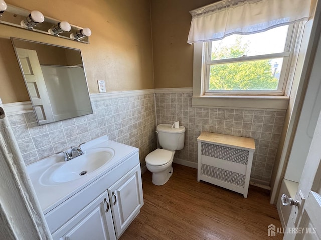 134 S Stevens Ave S, South Amboy, NJ 08879 - bathroom with radiator heating unit, tile walls, vanity, toilet, and a wainscoted wall
