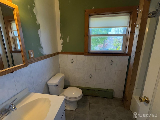 134 S Stevens Ave S, South Amboy, NJ 08879 - bathroom featuring tile walls, tile patterned floors, toilet, vanity, and a baseboard radiator