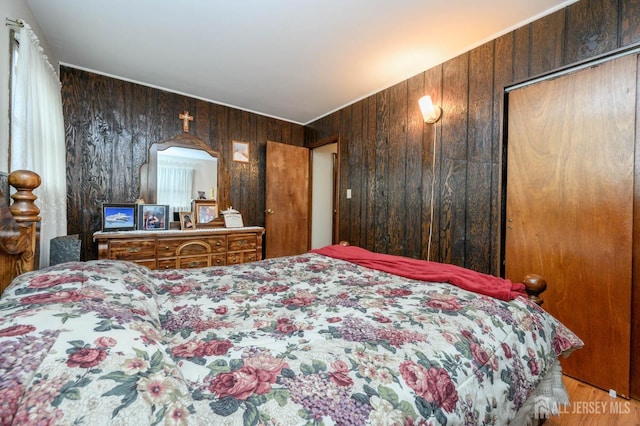 bedroom featuring hardwood / wood-style floors and wood walls