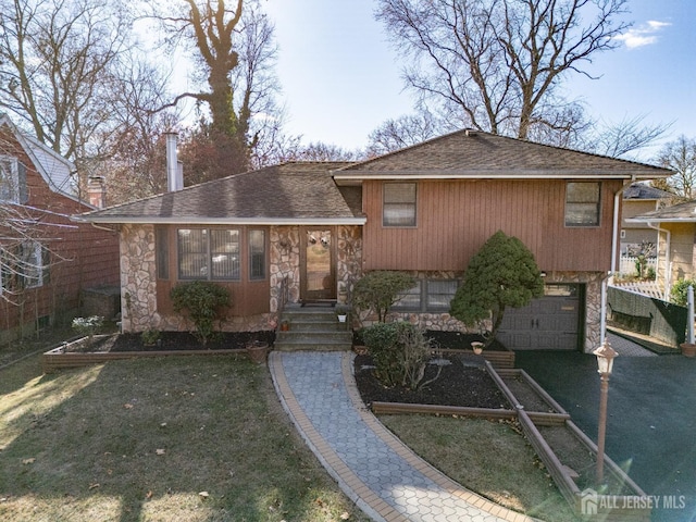 tri-level home with a front yard and a garage