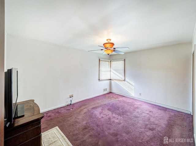 carpeted spare room featuring ceiling fan