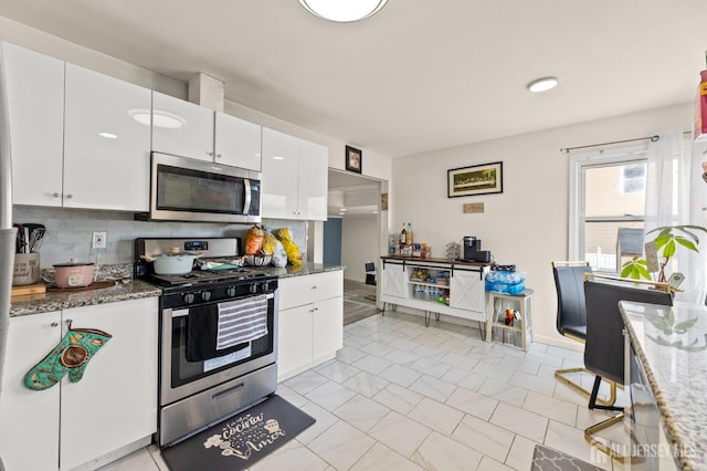 kitchen featuring white cabinets, tasteful backsplash, and appliances with stainless steel finishes