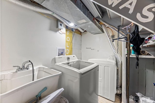 washroom featuring a sink, separate washer and dryer, and laundry area