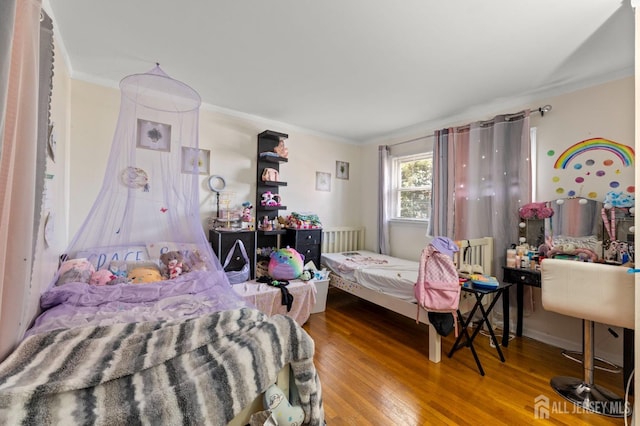 bedroom featuring wood finished floors and crown molding