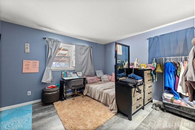 bedroom with baseboards and wood finished floors