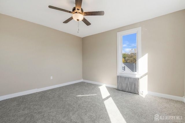 unfurnished room featuring carpet, radiator heating unit, and ceiling fan