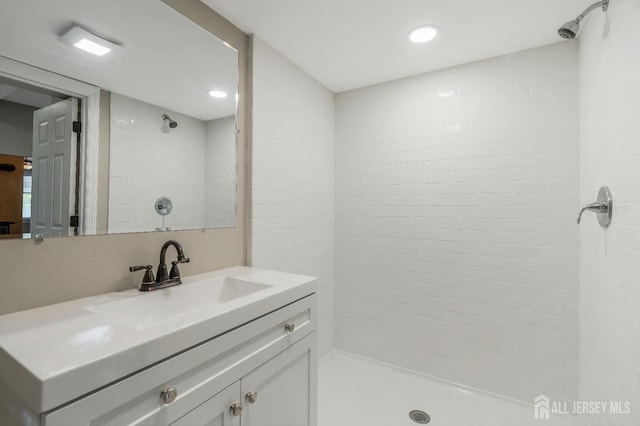 bathroom featuring a tile shower and vanity