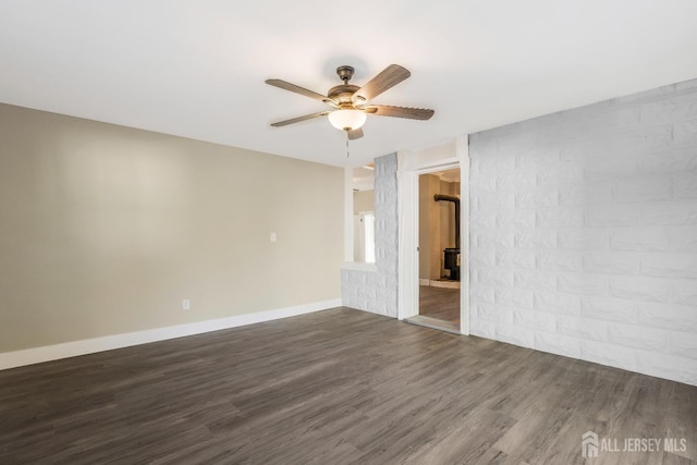 unfurnished room with ceiling fan and dark wood-type flooring