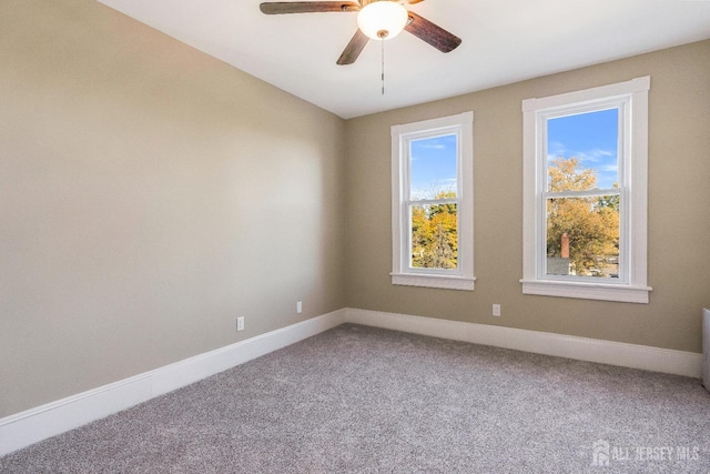 carpeted spare room featuring ceiling fan