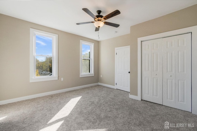 unfurnished bedroom with a closet, light colored carpet, and ceiling fan