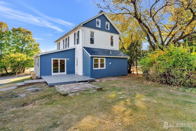 back of house featuring a lawn and a wooden deck