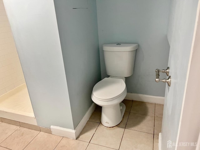 bathroom featuring a shower, tile patterned floors, and toilet