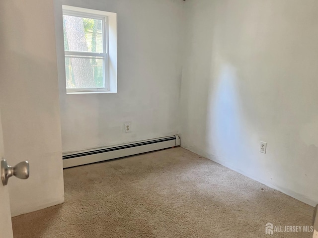 empty room featuring light carpet and a baseboard heating unit