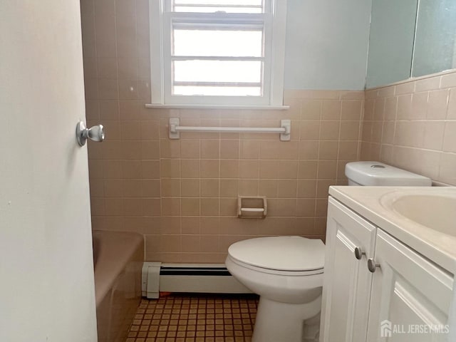 bathroom with tile patterned floors, vanity, a baseboard radiator, tile walls, and toilet