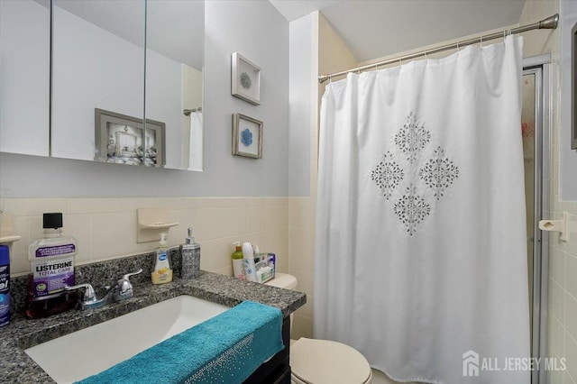 full bathroom with tile walls, toilet, vanity, and a shower with curtain