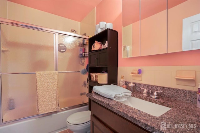 full bathroom featuring shower / bath combination with glass door, vanity, and toilet