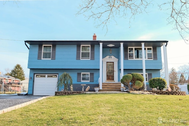 bi-level home with a front lawn, driveway, a chimney, and a garage
