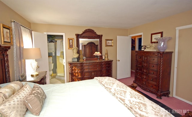 bedroom with carpet floors, ensuite bathroom, and baseboards