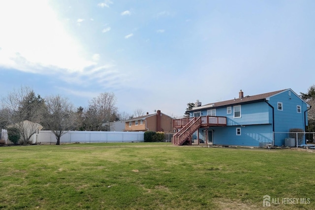 view of yard with central air condition unit, a fenced backyard, stairs, and a deck
