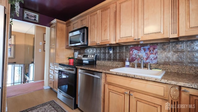 kitchen featuring light wood-style flooring, decorative backsplash, stainless steel appliances, and a sink