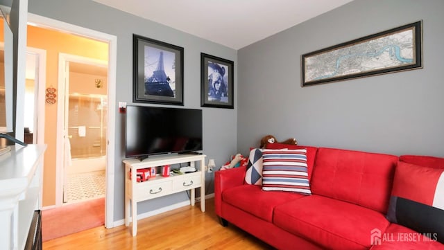 living area with baseboards and wood finished floors