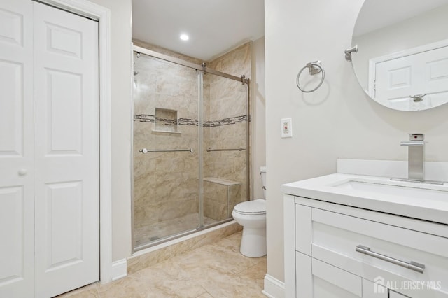 full bath featuring vanity, a shower stall, and toilet