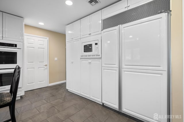 16 Darby Rd, East Brunswick, NJ 08816 - kitchen with built in appliances, white cabinetry, recessed lighting, and baseboards