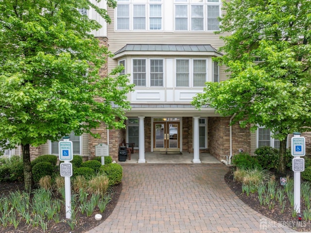 2206 Cedar Village Blvd, East Brunswick, NJ 08816 - entrance to property with french doors, a standing seam roof, a metal roof, and stone siding