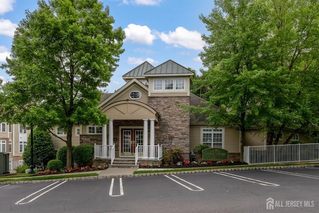2206 Cedar Village Blvd, East Brunswick, NJ 08816 - view of front of home with stone siding, french doors, uncovered parking, and board and batten siding