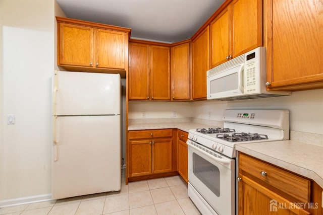 2206 Cedar Village Blvd, East Brunswick, NJ 08816 - kitchen featuring white appliances, light countertops, light tile patterned floors, and brown cabinets