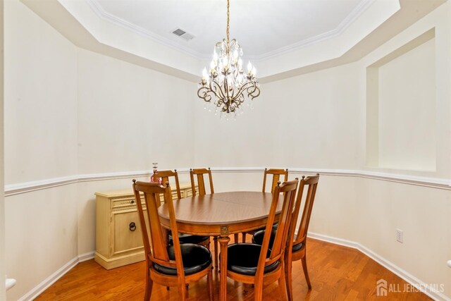 2206 Cedar Village Blvd, East Brunswick, NJ 08816 - dining area with light wood finished floors, a chandelier, ornamental molding, and a tray ceiling