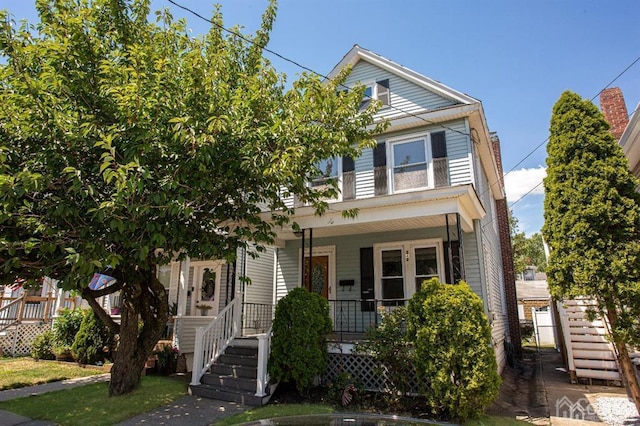 view of front of property featuring stairway and a porch