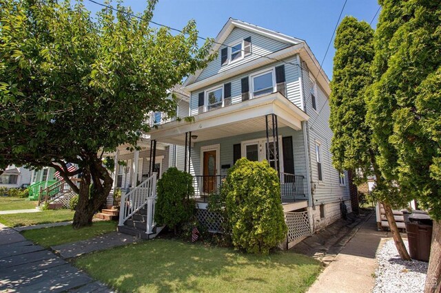 view of front of home featuring covered porch and a front yard