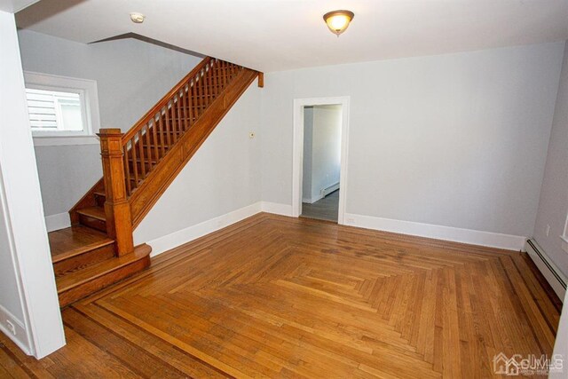 interior space with parquet flooring and a baseboard heating unit