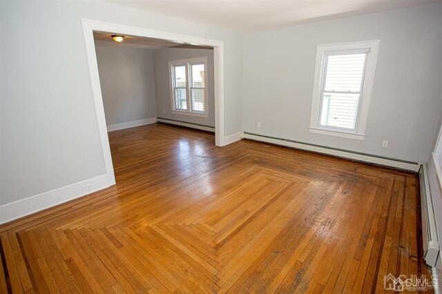 unfurnished room featuring a baseboard heating unit