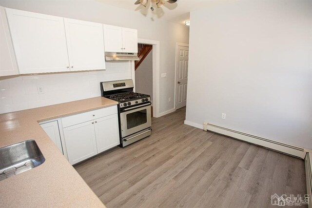 kitchen featuring a baseboard heating unit, stainless steel range with gas cooktop, white cabinetry, and light hardwood / wood-style flooring