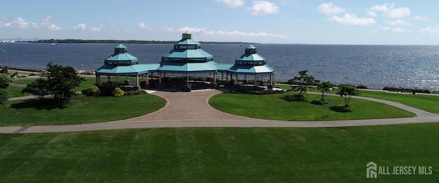 view of community featuring a water view, a gazebo, and a lawn