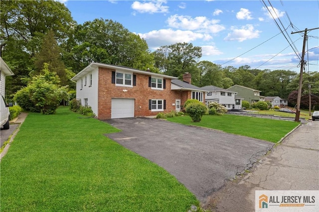 11 Amendola Dr, Netcong, NJ 07857 - view of front facade with asphalt driveway, a garage, brick siding, and a front lawn