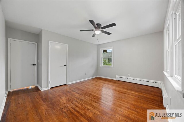 11 Amendola Dr, Netcong, NJ 07857 - unfurnished bedroom featuring a baseboard heating unit, wood finished floors, baseboards, and ceiling fan